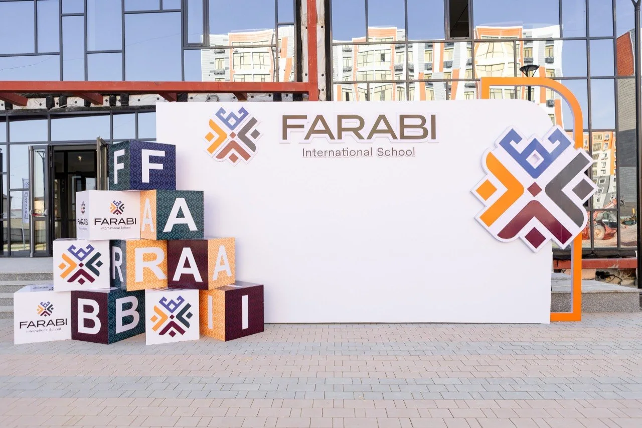 Фотозона: пресс-волл с символикой FARABI International School и объёмные буквы-кубы